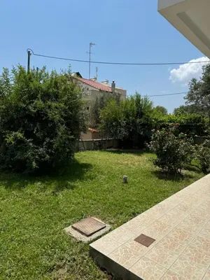 a yard with a house and some bushes and trees at Fotis House 2 in Afantou