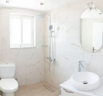 a white bathroom with a toilet and a sink at Fotis House 2 in Afantou