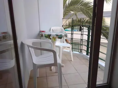 a balcony with two white chairs and a table at GT Apartment in Rhodes Town
