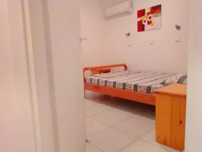 a small bedroom with a bed and a table at GT Apartment in Rhodes Town