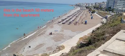 a beach with a bunch of people in the water at GT Apartment in Rhodes Town