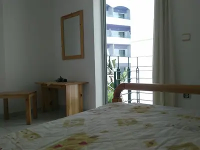 a bedroom with a bed and a view of a balcony at GT Apartment in Rhodes Town