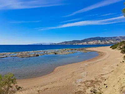 a beach with mountains in the background at Arancio independent room in Ecovilla on the beach in Apolakkiá