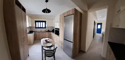 a kitchen with a table and chairs in a room at Déjà Blue in Archangelos