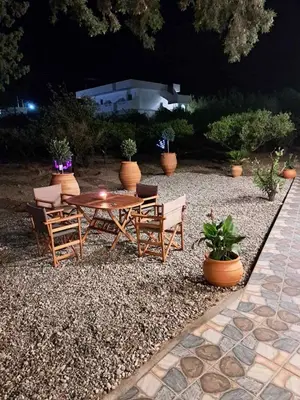 a patio with a table and chairs and plants at Déjà Blue in Archangelos