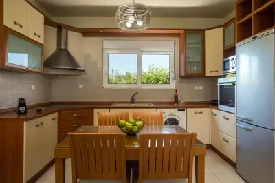 a kitchen with a table with a bowl of fruit on it at Villa Merelia in Afantou