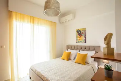 a bedroom with a bed with yellow pillows at Villa Merelia in Afantou