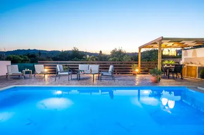 a pool with chairs and a table on a patio at Villa Merelia in Afantou
