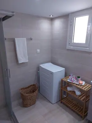 a bathroom with a washing machine and a window at Afandou Square Apartment in Afantou