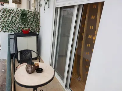 a small table and chair next to a sliding glass door at Afandou Square Apartment in Afantou