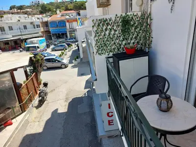 a balcony with a table and a view of a street at Afandou Square Apartment in Afantou
