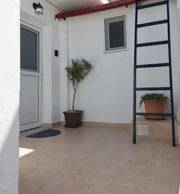 a room with a ladder and potted plants and a door at Afandou Square Apartment in Afantou