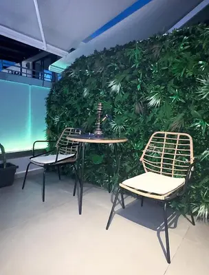 a green wall with two chairs and a table at Rodosrooms in Rhodes Town