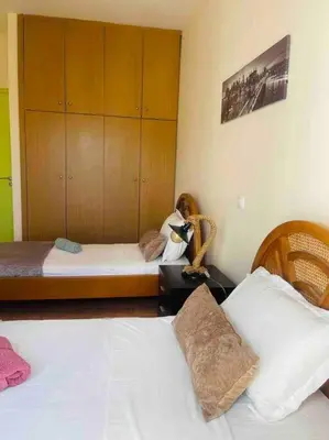 a bedroom with two beds and a cabinet at George House in Archangelos
