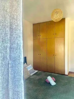a bedroom with a bed with pink shoes on the floor at George House in Archangelos