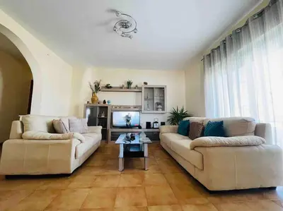a living room with two couches and a tv at George House in Archangelos