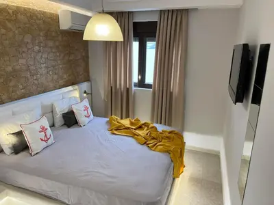 a bedroom with a bed with a yellow blanket on it at 2-Luxury jacuzzi white suite by the sea in Rhodes Town