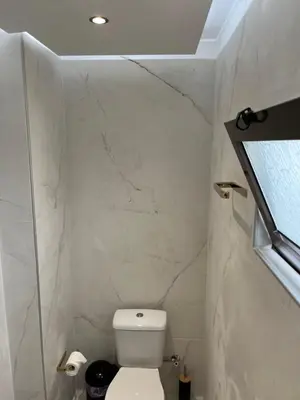 a bathroom with a white toilet and a window at 2-Luxury jacuzzi white suite by the sea in Rhodes Town