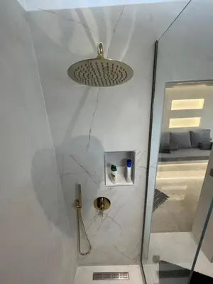a shower with a glass door and a ceiling at 2-Luxury jacuzzi white suite by the sea in Rhodes Town