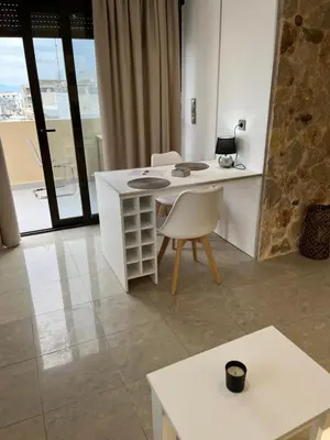 a white table and chairs in a room with a window at 2-Luxury jacuzzi white suite by the sea in Rhodes Town