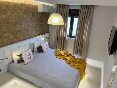 a bedroom with a bed with a yellow blanket on it at 2-Luxury jacuzzi white suite by the sea in Rhodes Town
