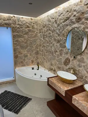 a bathroom with a tub and a sink and a mirror at 2-Luxury jacuzzi white suite by the sea in Rhodes Town