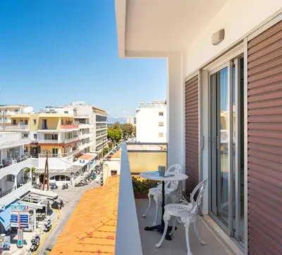 a balcony with a table and chairs and a cross at Emelia Cozy Apartment in Rhodes Town