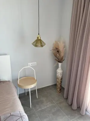 a bedroom with a chair and a table and a lamp at Vixen Apartment Studio 2 in Theologos