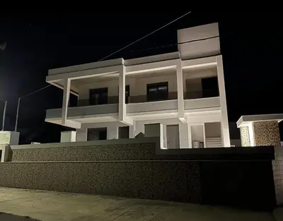 a white apartment building at night with the lights on at Vixen Apartment Studio 2 in Theologos