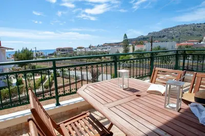 a wooden table on a balcony with a view at Villa Calliope Lardos in Lardos