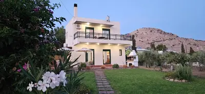 a white house with a hill in the background at Villa Calliope Lardos in Lardos
