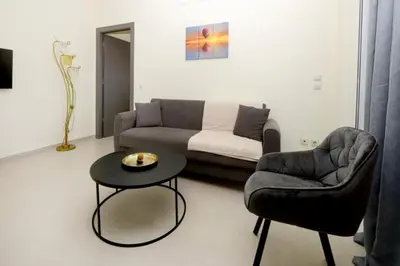 a living room with a couch and a table and a chair at Elli Garden View - Spacious Fully Equipped Apartment in Kremasti