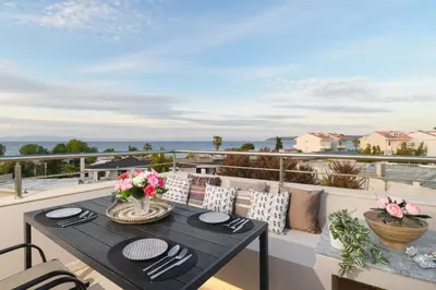 a dining table on a balcony with a view of the ocean at Marilena Mare Seaside & Jacuzzi House 50meters from sea in Ialyssos