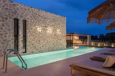 a swimming pool in front of a building at Mirena Luxury Living-Casa Di Ria in Afantou