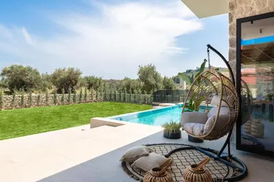 a swing sitting on a patio next to a pool at Mirena Luxury Living-Casa Di Ria in Afantou