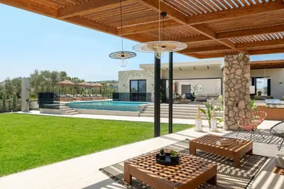a backyard with a swimming pool and a house at Mirena Luxury Living-Casa Di Ria in Afantou