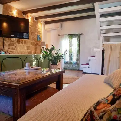 a bedroom with two beds and a table and a tv at Ioli's Home - Medieval Town in Rhodes Town