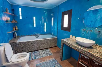 a blue bathroom with a tub and a toilet and a sink at Ioli's Home - Medieval Town in Rhodes Town