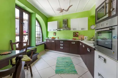 a kitchen with green walls and wooden cabinets at Ioli's Home - Medieval Town in Rhodes Town