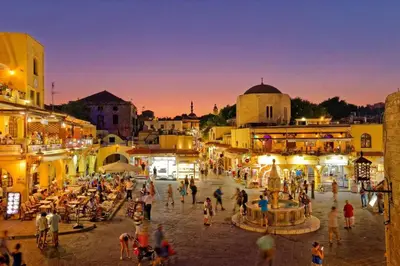 a group of people walking around a city at night at Ioli's Home - Medieval Town in Rhodes Town