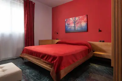 a red bedroom with a bed and a red wall at Fata Morgana Apartment in Ialyssos