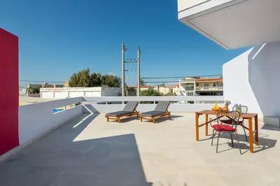 a patio with a table and chairs on a roof at Fata Morgana Apartment in Ialyssos