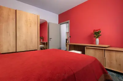 a red room with a bed with a red wall at Fata Morgana Apartment in Ialyssos
