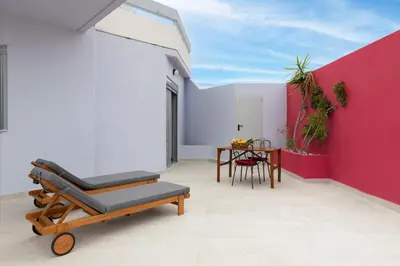 a room with a red and white wall and a table at Fata Morgana Apartment in Ialyssos