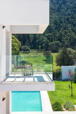 a white house with a swimming pool and a table at Villa Myrto in Ialyssos