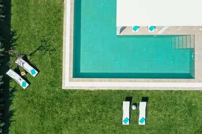 an overhead view of a swimming pool with lawn chairs at Villa Myrto in Ialyssos