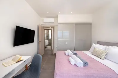 a bedroom with two beds and a tv on a wall at Villa Myrto in Ialyssos