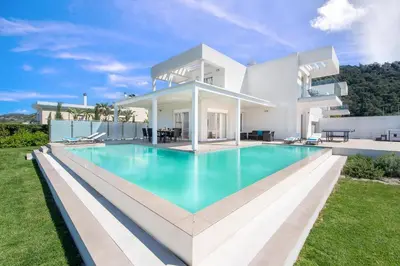 a large white house with a large swimming pool at Villa Odysseas in Ialyssos