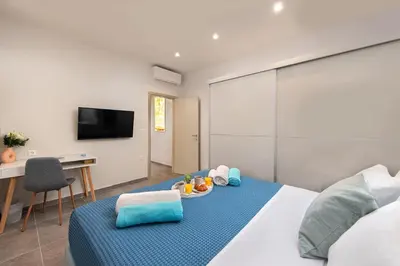 a room with a bed and a desk and a tv at Villa Odysseas in Ialyssos