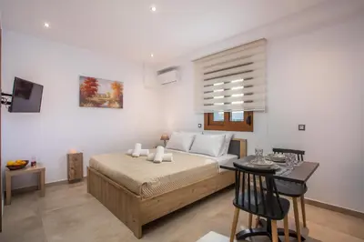 a bedroom with a large bed and a table with a table at M&E APARTMENTS in Haraki